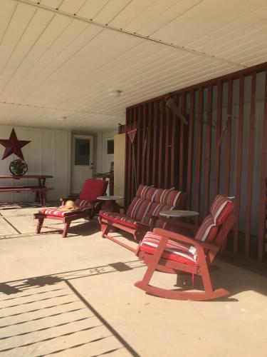 a group of red benches sitting on a porch at Dora's Country Cottage in Escalante