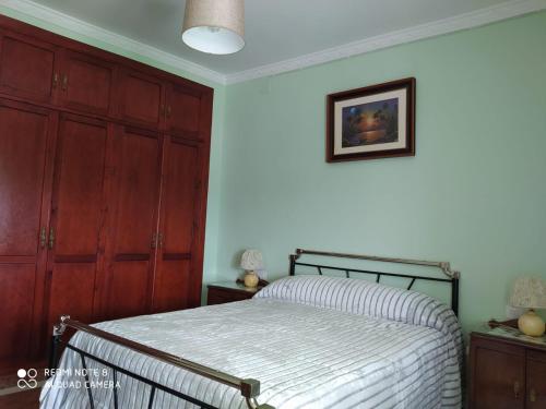 a bedroom with a bed and wooden cabinets at La Casa del Montero in El Pedroso
