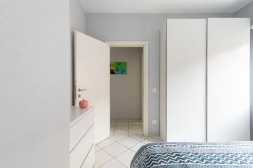 a bedroom with white walls and a blue bed at Lido Apartments by Quokka 360 - 5 min from the centre and the Lugano Lido in Lugano