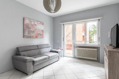 a living room with a couch and a tv at Lido Apartments by Quokka 360 - 5 min from the centre and the Lugano Lido in Lugano
