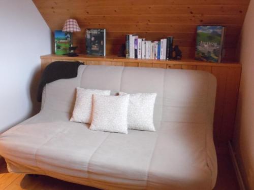 a white couch with two pillows in a room at Chalet des Clarines in Saint-Genès-Champespe
