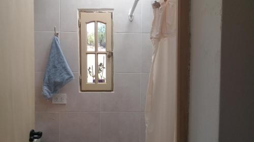 a bathroom with a shower curtain and a mirror at El Cardón,habitación privada en el campo in Humahuaca