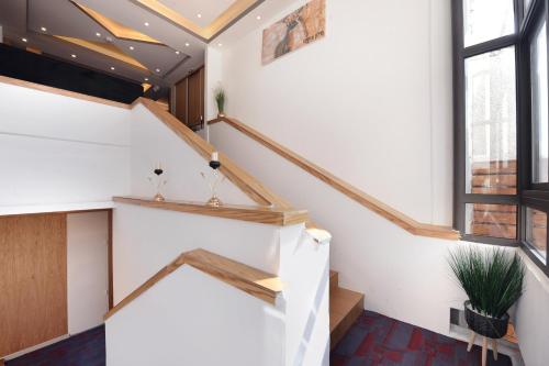 a staircase in a room with white walls and windows at Tzukim Boutique - Desert Traveler's Hotel in Mitzpe Ramon - מלון בוטיק צוקים in Mitzpe Ramon