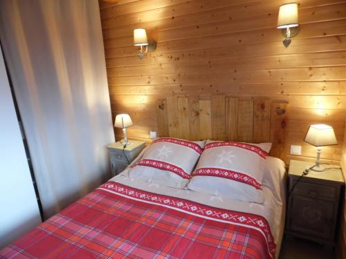 Saint-Genès-ChampespeにあるChalet des Clarinesのベッドルーム1室(ベッド1台、赤と白の枕2つ付)