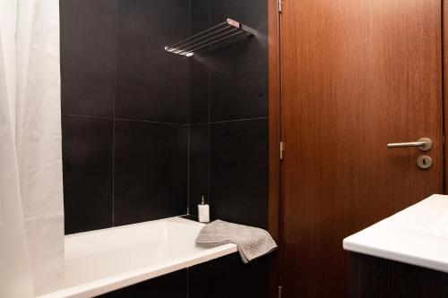 a bathroom with a shower with a sink and a mirror at Modern 2Bed Rooftop Pool & Gym, Marina &Meia Praia Lagos in Lagos