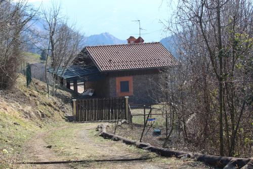 a small house on a hill next to a dirt road at I laghi di Spettino in Antea