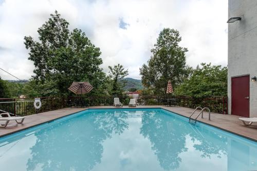 a large swimming pool with a fence and trees at Laurel Inn in Gatlinburg