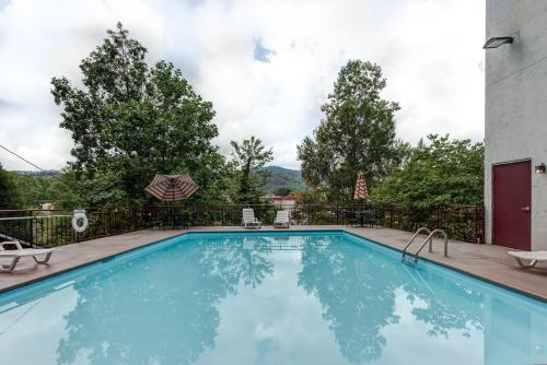 une grande piscine avec une clôture et des arbres dans l'établissement Laurel Inn, à Gatlinburg