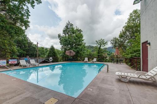 - une piscine avec des chaises longues à côté d'un bâtiment dans l'établissement Laurel Inn, à Gatlinburg