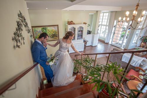 a bride and groom walking down the stairs at their wedding at Pousada Cheverny - Fácil acesso ao centrinho e Baden Bar in Campos do Jordão