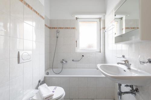 a bathroom with a sink and a toilet and a bath tub at Lido Apartments by Quokka 360 - 5 min from the centre and the Lugano Lido in Lugano