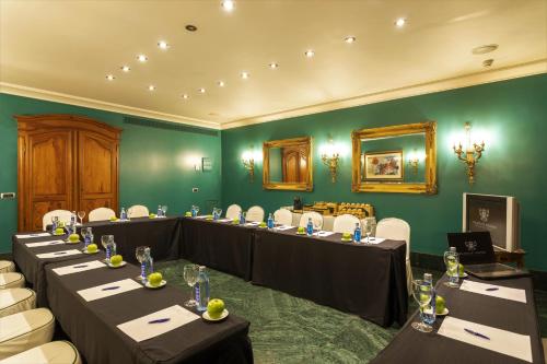 a conference room with tables and chairs and green walls at Sercotel Palacio de Tudemir in Orihuela