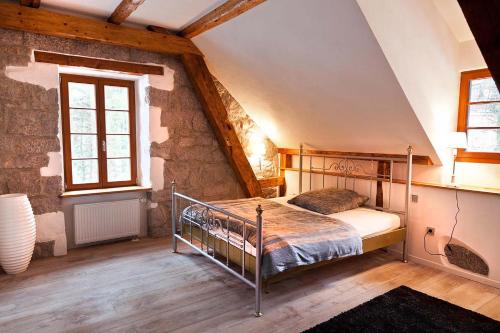 a bedroom with a metal bed in a attic at Herrenhaus Schluchsee in Schluchsee