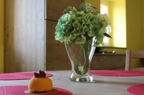 a vase with flowers and a cake on a table at I laghi di Spettino in Antea