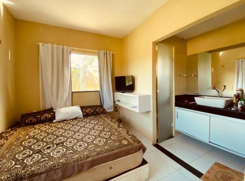 a bedroom with a large bed and a sink at Casa em flecheiras com piscina in Flecheiras