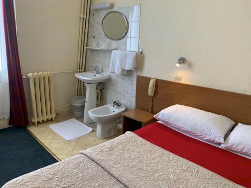 1 dormitorio con cama, lavabo y aseo en Hotel Liberty en París