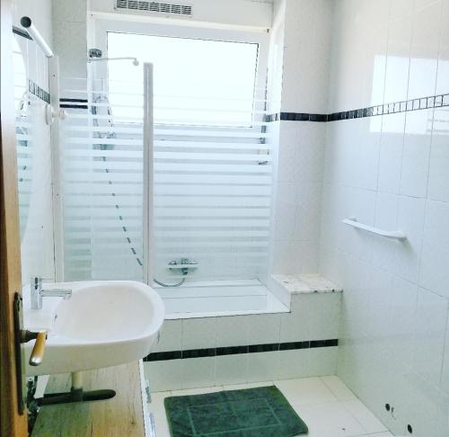 a white bathroom with a sink and a shower at Txoko Maitea Pentsioa in Urnieta