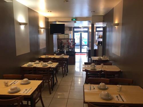 une salle à manger avec des tables, des chaises et une télévision dans l'établissement Hotel Liberty, à Paris