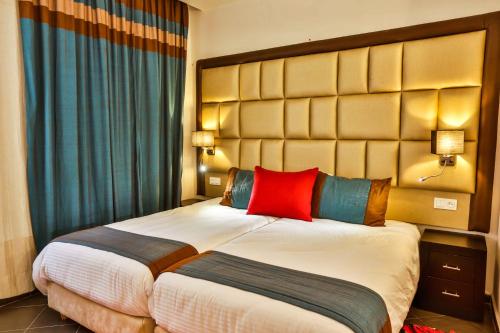 a hotel room with two beds with red and blue pillows at Hôtel Mechouar Plaza in Essaouira