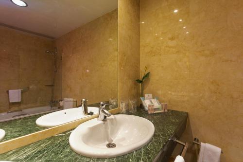 La salle de bains est pourvue d'un lavabo blanc et d'un miroir. dans l'établissement Sercotel Palacio de Tudemir, à Orihuela