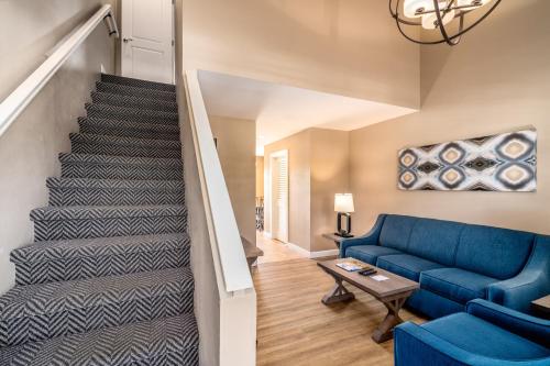a living room with a blue couch and stairs at Waterside Suites and Marina in Key Largo
