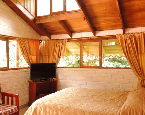 Schlafzimmer mit einem Bett und einem Flachbild-TV in der Unterkunft La Casta in Patate