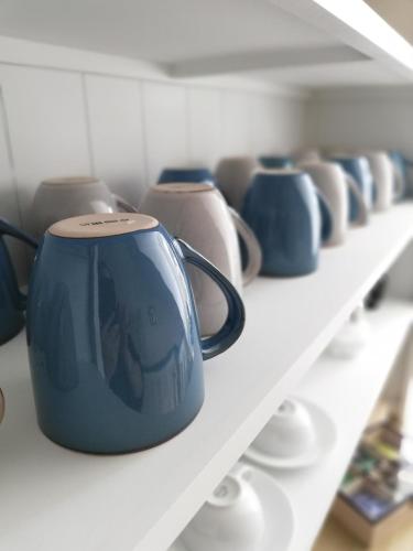 a row of blue and white pots on a shelf at Hotel Garni Friesenhuus in Greetsiel