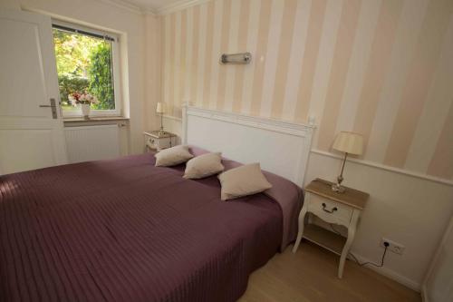 a bedroom with a purple bed with a window at Timmendorf - Strandnah in Timmendorfer Strand