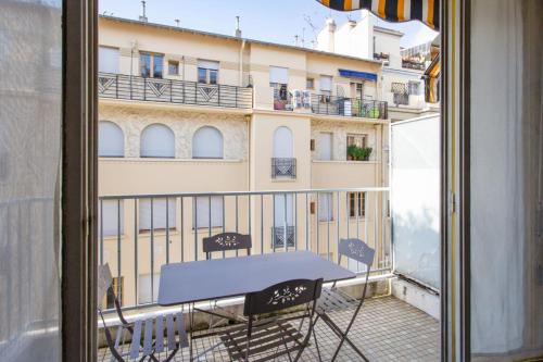 - une table sur un balcon avec vue sur un bâtiment dans l'établissement Le Refuge Acajou - Welkeys, à Nice