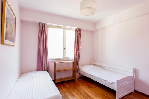 une chambre avec deux lits et une fenêtre dans l'établissement Le Refuge Acajou - Welkeys, à Nice