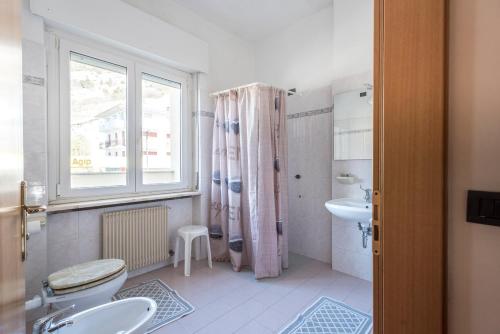 łazienka z toaletą, umywalką i oknem w obiekcie Hotel Rubino w orbole