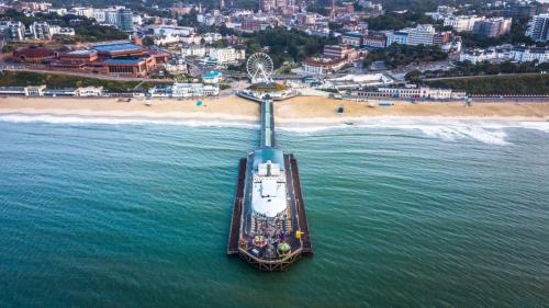 a boat in the water next to a beach at Brooklands Lodge in Bournemouth