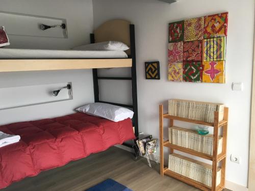 a bedroom with a bunk bed with a red bedspread at Rollarthouse in Rollamienta
