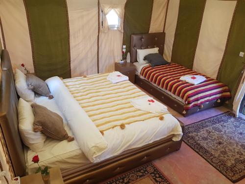 pokój z 2 łóżkami w namiocie w obiekcie Dune Merzouga Camp w mieście Merzouga