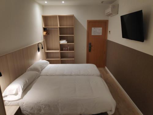
a bedroom with a bed and a desk at Hostal Conde Güell in Barcelona
