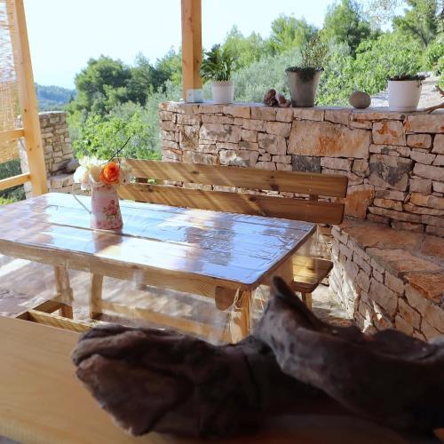 a wooden table and a bench on a patio at Greenside Cottage Lumi in Vela Luka
