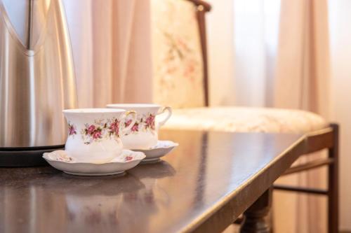 two cups and saucers sitting on a table at Seven cafe & hotel in Pogradec