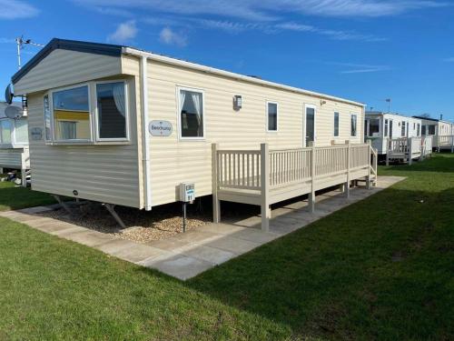 a white trailer with a porch on a grass field at Rejuven8 Rentals - Silver Beach - Ingoldmells - Skegness in Ingoldmells