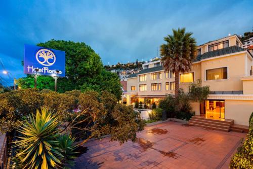 a hotel with a blue sign in front of a building at Hotel Florida in Ambato