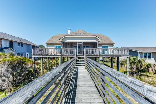 a house with a boardwalk leading to a house at Turtle Watch II in Folly Beach