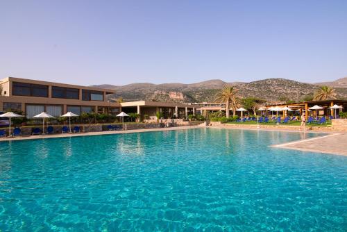 una gran piscina de agua azul frente a un hotel en Kernos Beach Hotel & Bungalows, en Malia