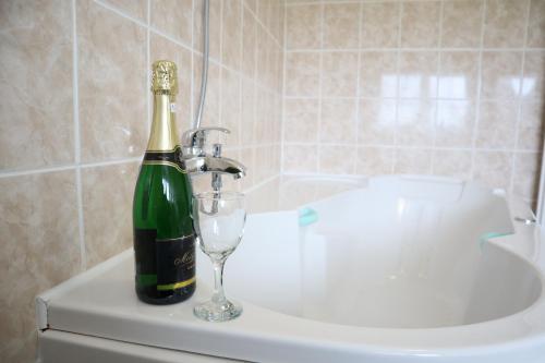 - Botella de champán y copa de vino en la bañera en Hotel 66 en Fryšták