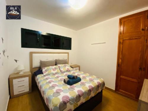 ein Schlafzimmer mit einem Bett mit einem blau ausgestopften Tier darauf in der Unterkunft Giulia Puerto del Carmen in Puerto del Carmen