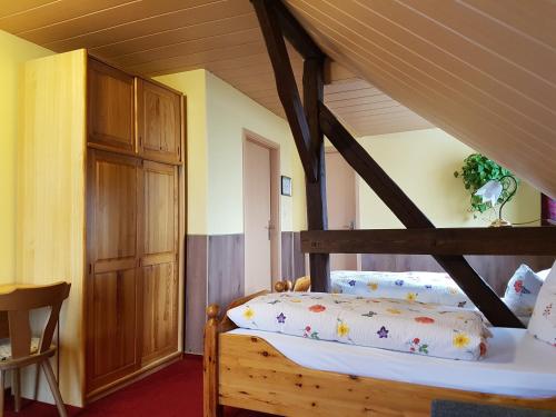 una camera con letto in legno e cuscini sopra di Pension zum Wiesengrund a Frauenhagen