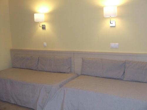 two beds in a room with lights on the wall at Alojamento Local Primavera in Amadora