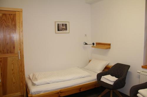 ブダペストにあるRotter Lajos Turistaházのベッドと椅子付きの小さな部屋です。