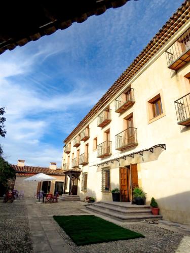 a large white building with a lawn in front of it at Hotel Río Escabas, Serranía de Cuenca in Cañamares