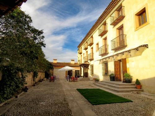 a courtyard of a building with a grass yard at Hotel Río Escabas, Serranía de Cuenca in Cañamares