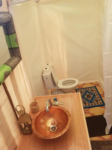 a bathroom with a wooden sink and a toilet at Dune Merzouga Camp in Merzouga
