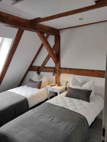 deux lits dans une chambre mansardée avec poutres en bois dans l'établissement Großes schönes Ferienhaus mit Garten für 12 Personen erwartet Sie im Harz!, à Sankt-Andreasberg